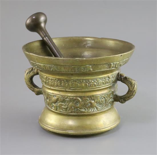 An early 17th century Dutch or German bronze mortar, diameter 7.5in. height 5.5in., with an associated pestle